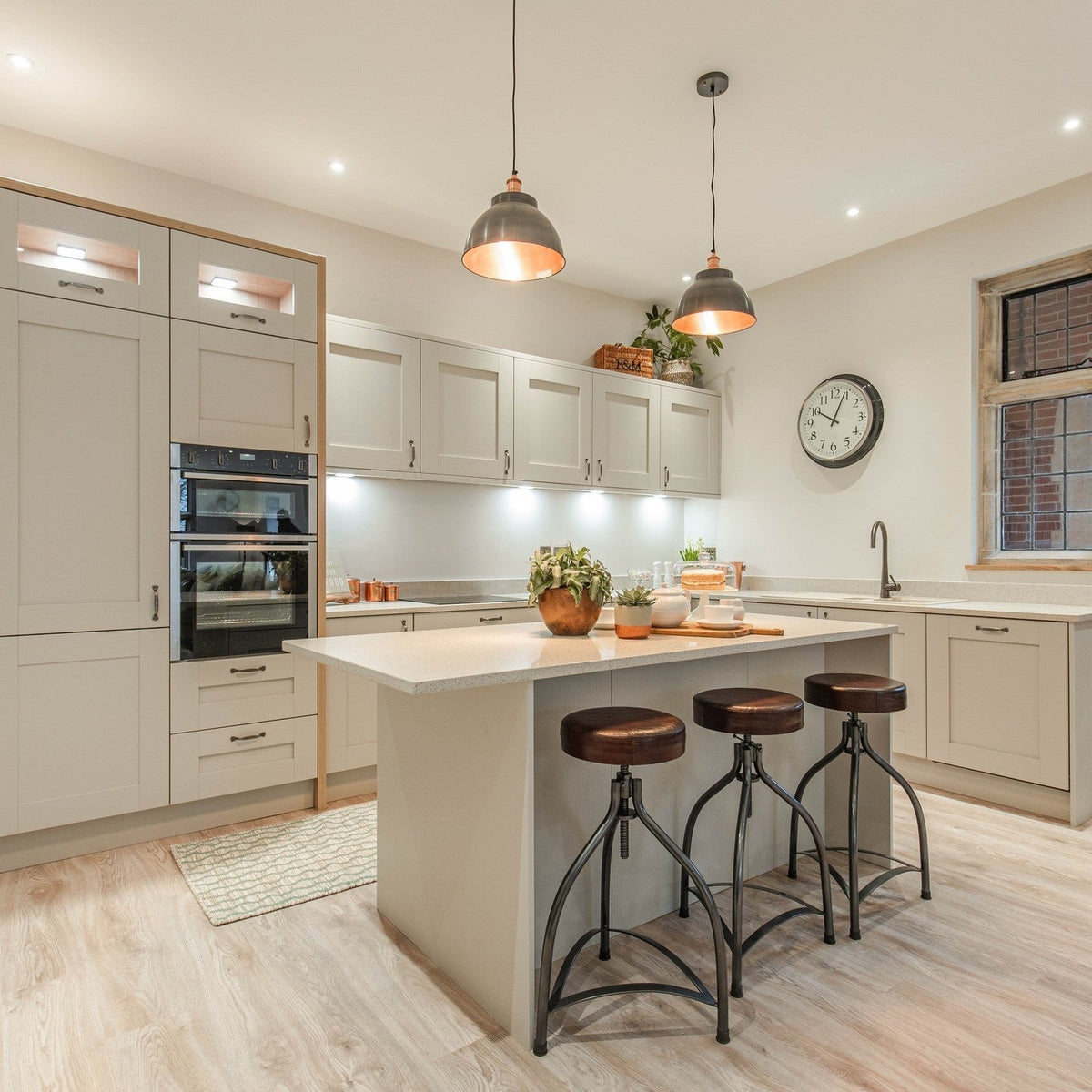 Pewter and copper dome pendant above white kitchen stools