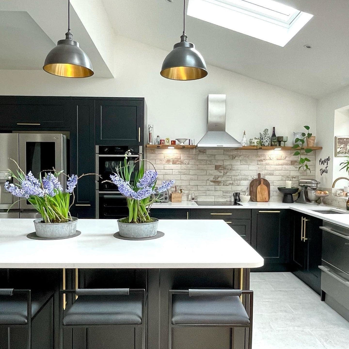 Copper-lined dome pendant in a monochrome kitchen