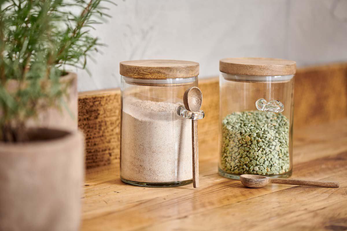 Kossi storage jar showing glass loop and wooden spoon