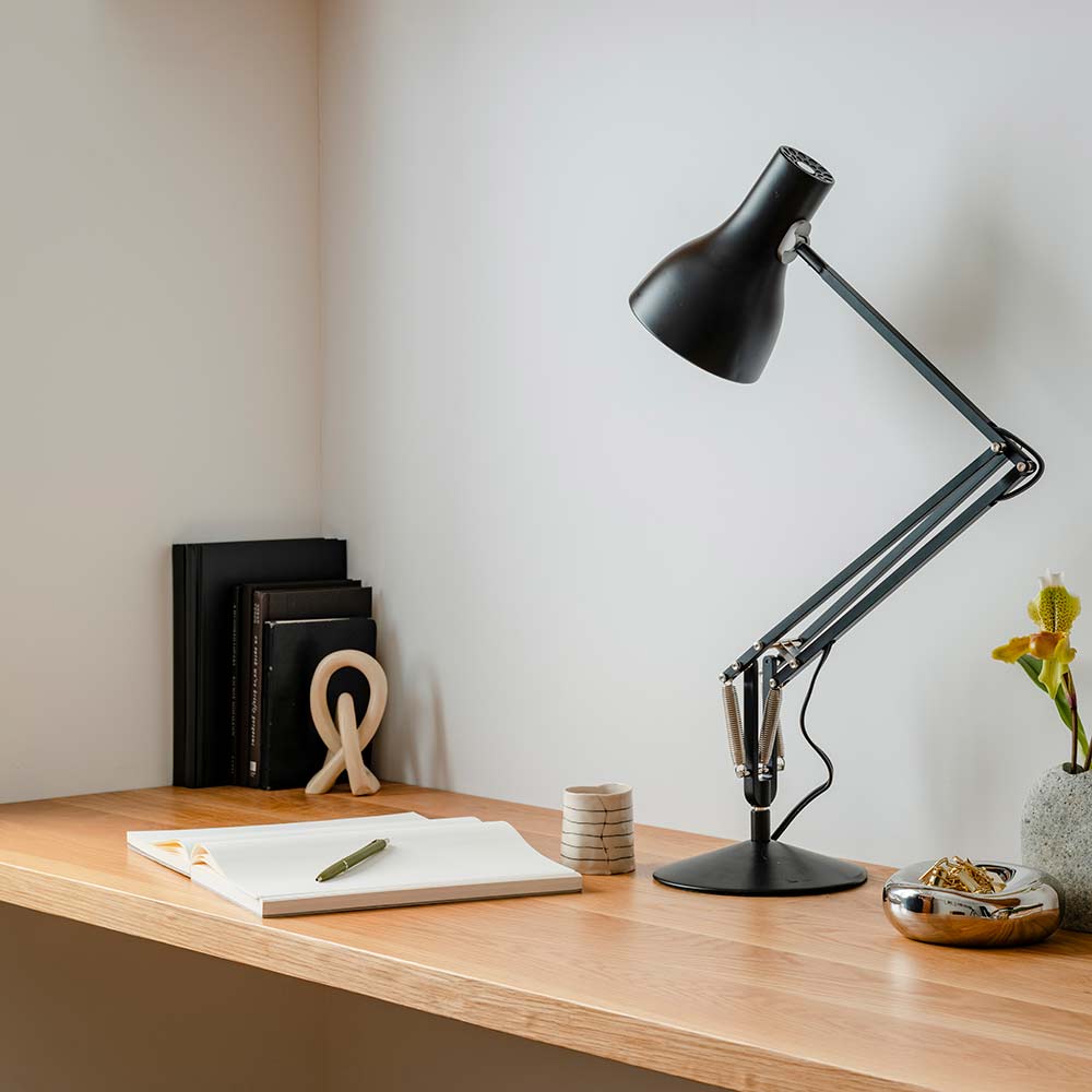Type 75 desk lamp lighting a wooden desk with notebook and pen