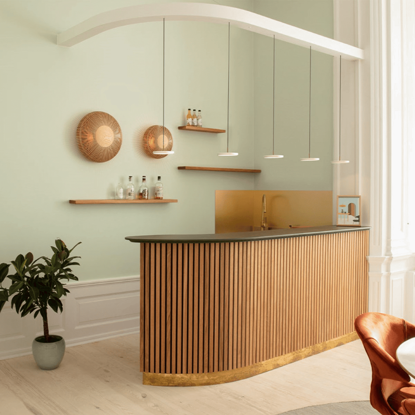 White pendant lights and rattan wall lights in a bright sage-green room with light oak bar